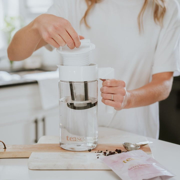 Tease Wellness Cold Brew Iced Tea & Coffee Maker Kit with clear glass pitcher, stainless steel infuser, and pink Cortina tea .