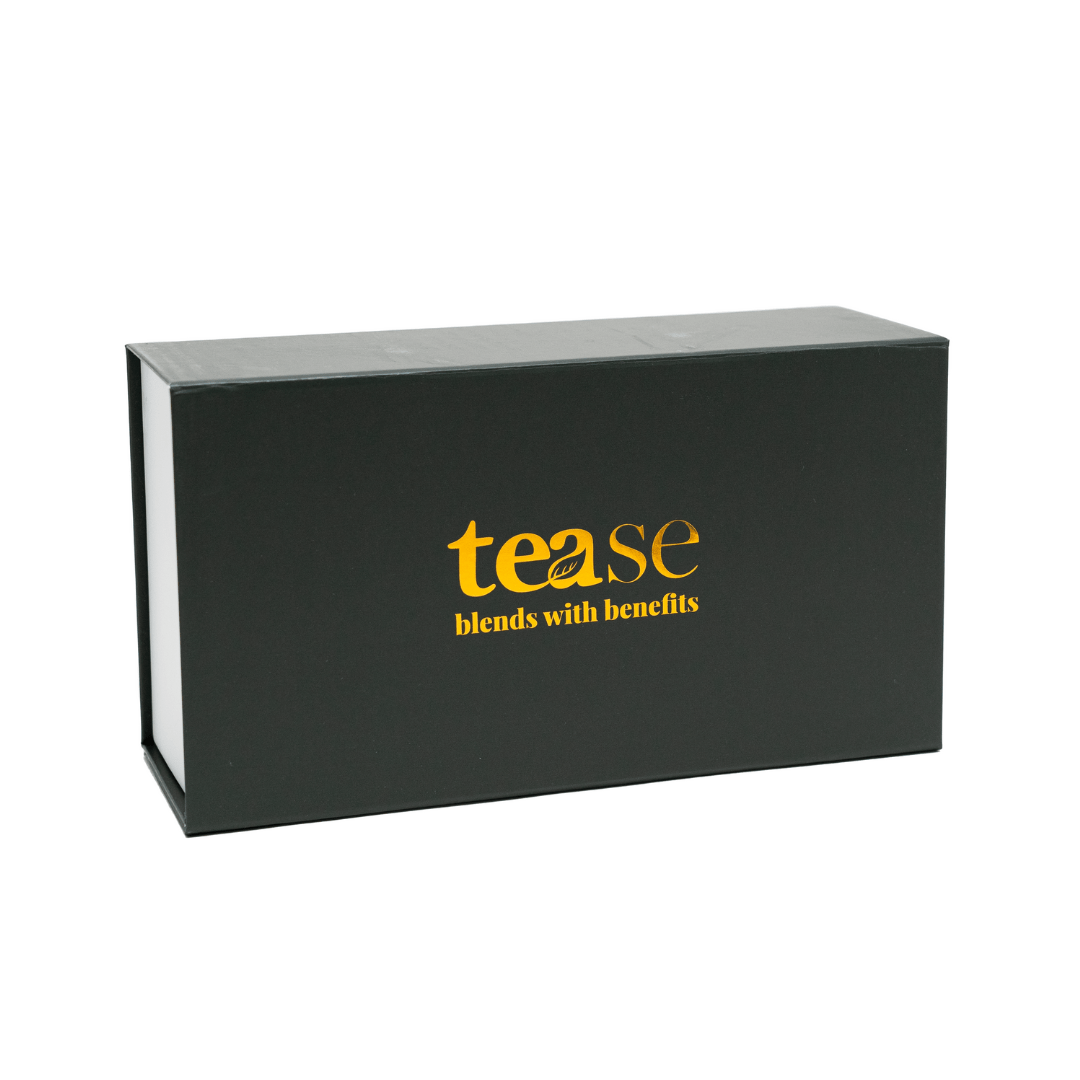 Tease Wellness gift box in black with gold logo, sleek rectangular packaging for tea blends.