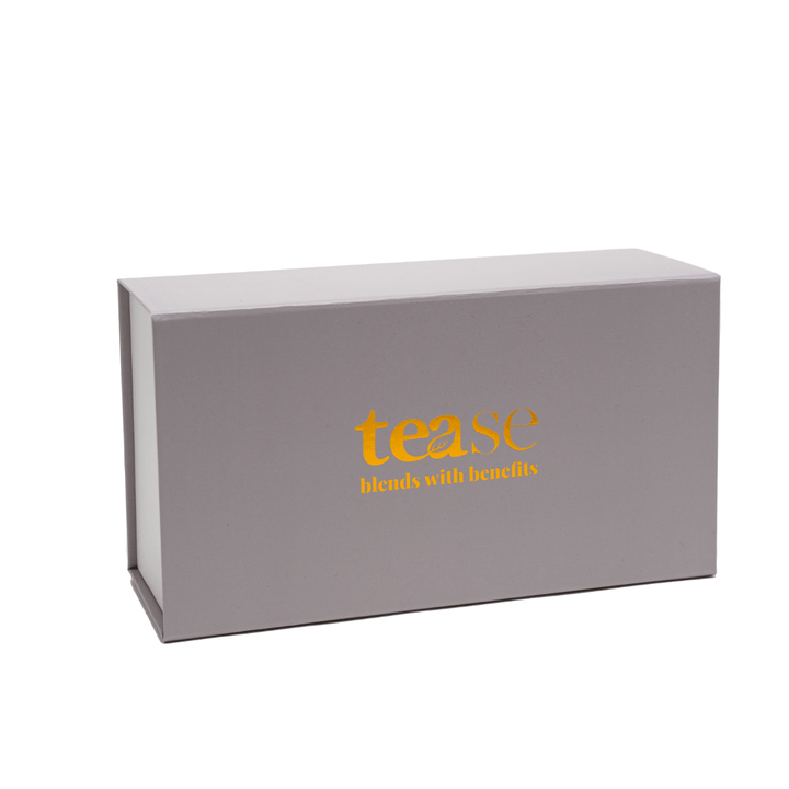 Tease Wellness gift box in taupe with gold "tease blends with benefits" logo, sleek rectangular packaging.