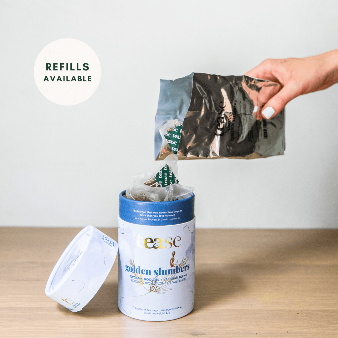Tease Wellness Golden Slumbers organic sleep tea refill pouch above blue and white cylindrical tea container with loose leaf .