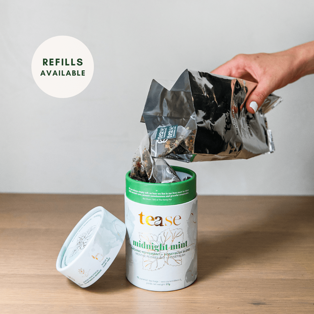Tease Wellness Midnight Mint organic tea blend tube with loose leaf being poured from black refill pouch.