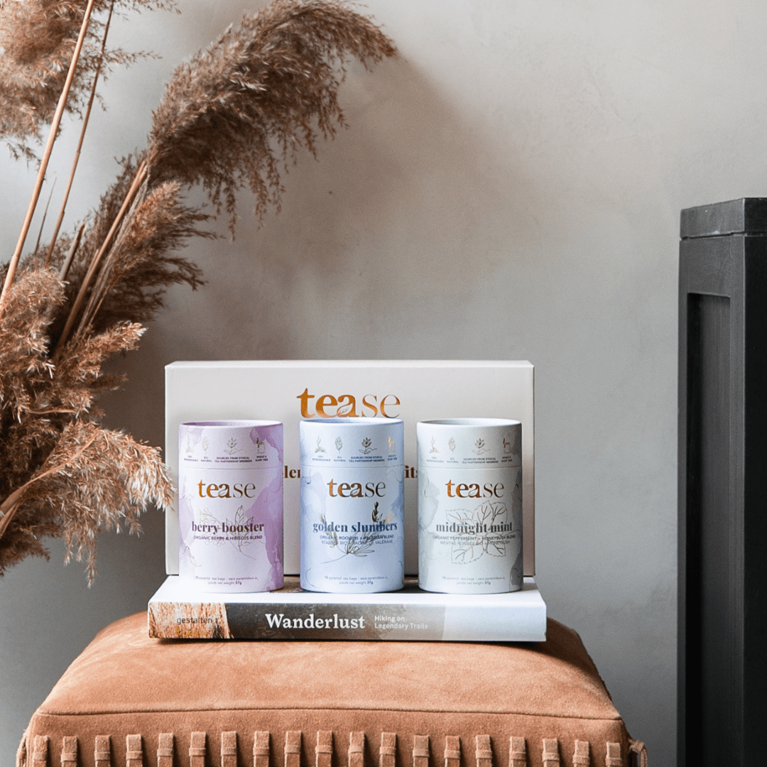 Tease Wellness The Organics Gift Set with three tea blends in white, lavender, and beige tins featuring organic ingredients.